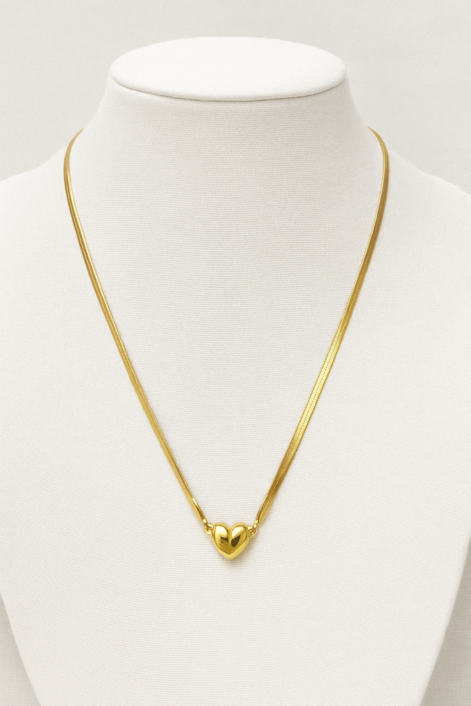 Elegant heart pendant necklace displayed on a mannequin, featuring a stylish gold-plated chain design.